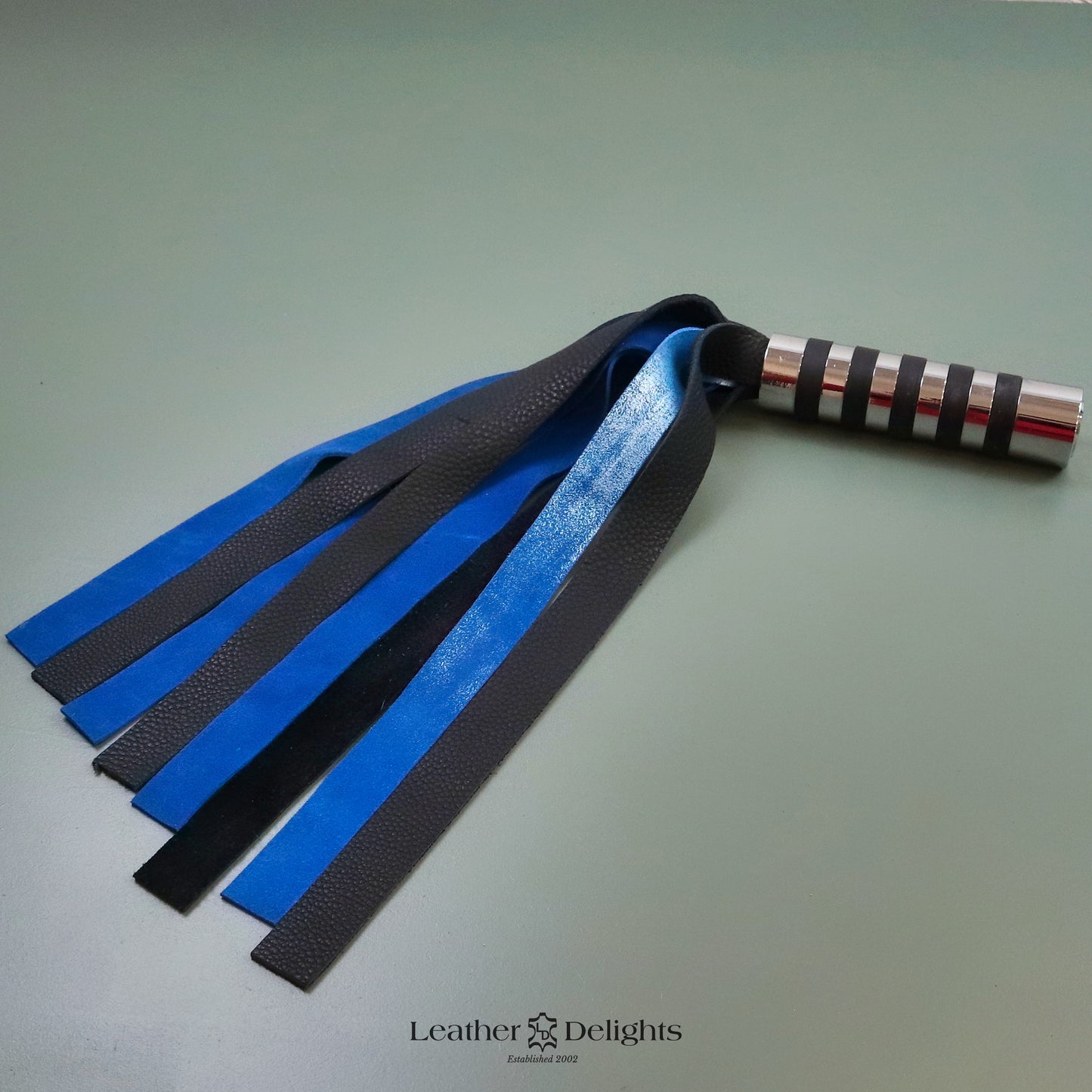 Martinet en daim bleu métallisé terni et cuir noir avec poignée argentée