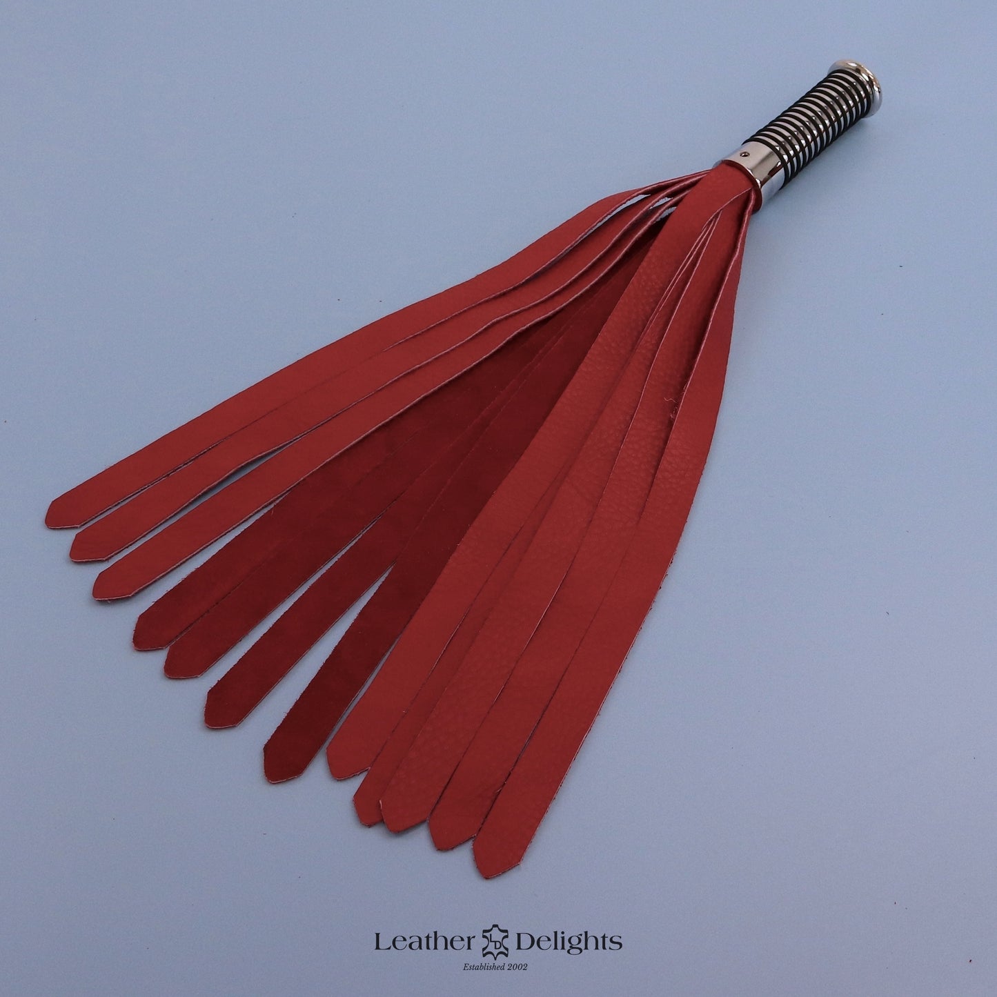 Flogger en cuir vert et noir avec poignée argentée